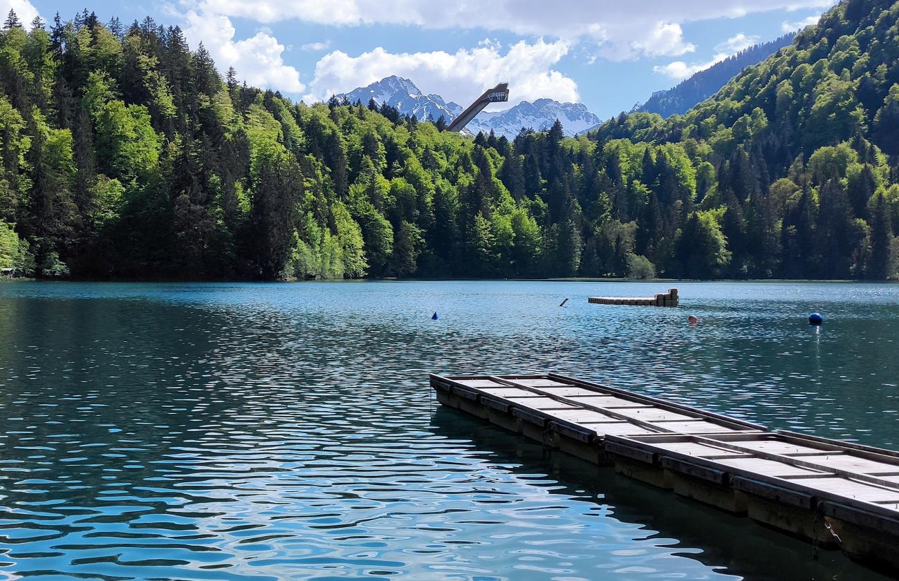 Ein Sprung ins kalte Türkis: Baden unter der Skiflugschanze im Freibergsee